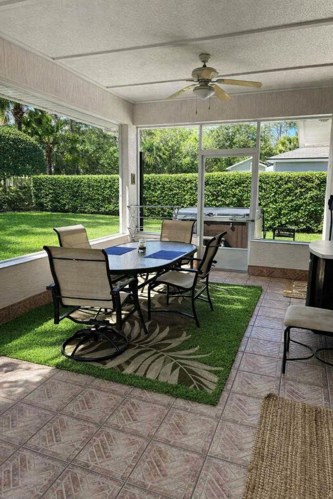 Screened lanai with dining table overlooking the tropical backyard